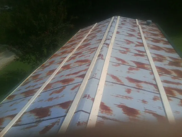 Rusted metal roof panels with new wood purlins before replacement — Storm Damage Roof Repair in Cumbola by Roofing Brothers