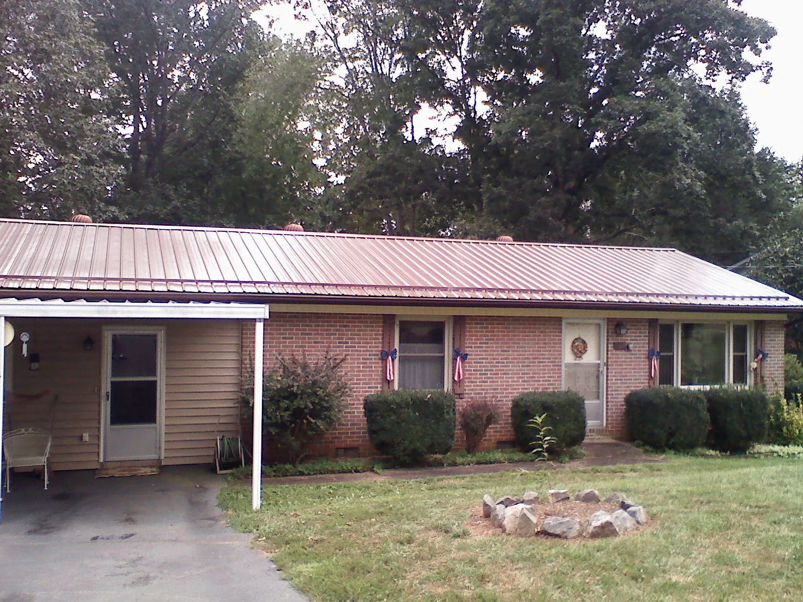 Bronze metal roof and carport on a brick ranch home — Roof Repair work by our crew in Cumbola
